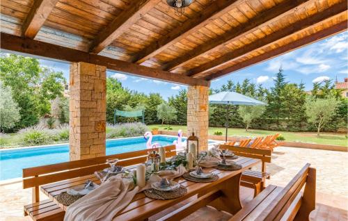 an outdoor dining room with a table and a pool at Holiday Home Muntic Iii in Muntić
