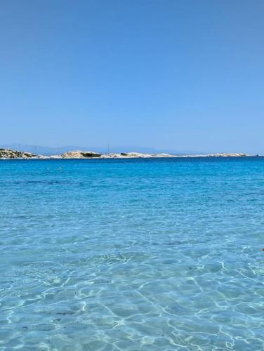 a large body of blue water with rocks in the background at Charming Sardinian Dream Home in Marazzino