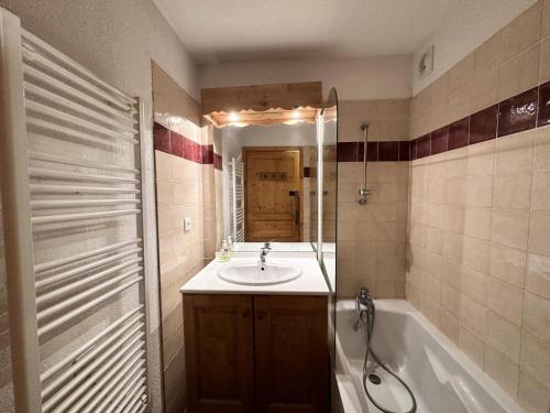 une salle de bain avec un lavabo, une baignoire et un miroir dans l'établissement Résidence L'ecrins Des Neiges - APPARTEMENT T3 SPACIEUX PROCHE DES PISTES MAE-5361, à Vars