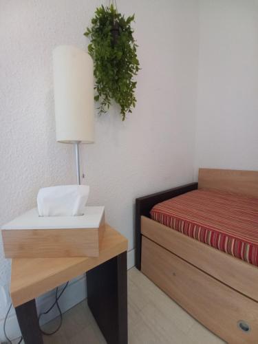 une chambre avec un lit et une table avec une lampe dans l'établissement Coquet studio 4 pers, piscine,clim mobile, plage a 300 m,à 5min a pied du Lydia, au Barcarès