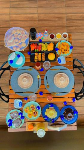 a table with many plates of food on it at Pousada Mon Gâté in Japaratinga