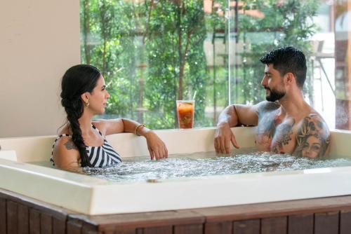 a man and a woman sitting in a bathtub at Complexo Eco Cataratas Resort by SJ in Foz do Iguaçu