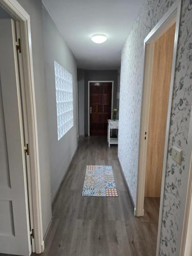 a hallway with a door and a rug on the floor at Spacious apartment with sea view in O Grove, 110 m² in O Grove