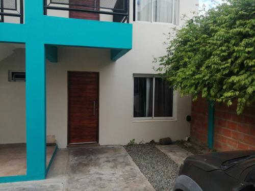 a house with a door and a tree in front of it at Javier 1 in Santa Teresita