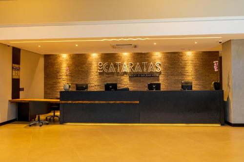 an office with a reception desk and a sign on the wall at Complexo Eco Cataratas Resort by SJ in Foz do Iguaçu