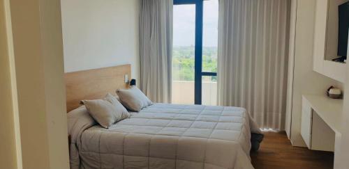 a bedroom with a bed and a large window at EG12 Playa Grande in Mar del Plata