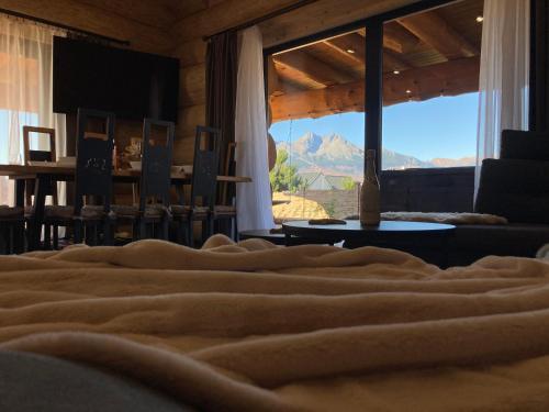 a bed in a room with a view of a mountain at Amia Chalet in Veľká Lomnica