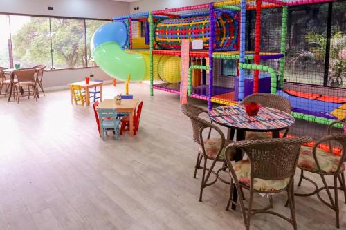 a room with tables and chairs and a water slide at Complexo Eco Cataratas Resort by SJ in Foz do Iguaçu
