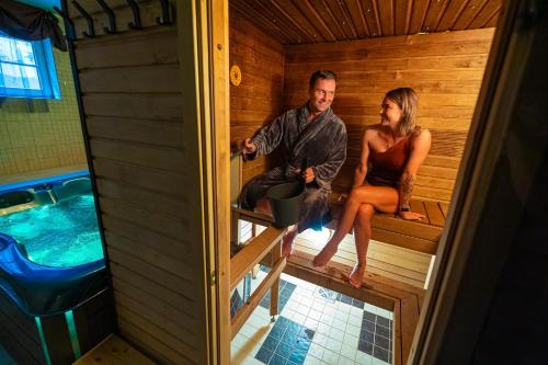 a man and a woman sitting in a sauna at SPA Hotell Peetrimõisa Villa in Viljandi