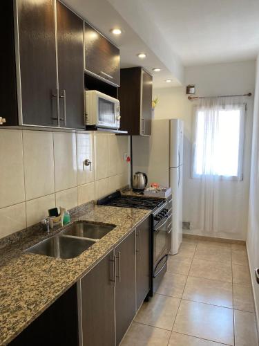 a kitchen with a sink and a refrigerator at Complejo Pampa 1 in Santa Rosa