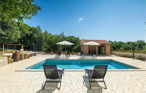 a pool with chairs and umbrellas next to a house at Villa Stora Kuca in Krapan