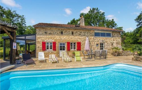 a stone house with a swimming pool in front of it at Cozy Home In Augignac in Augignac