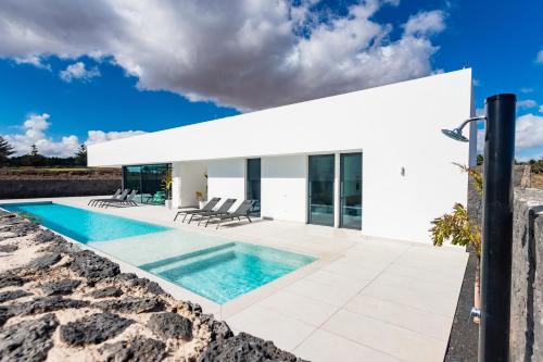 a white villa with a swimming pool at Villa Tenik in Teguise