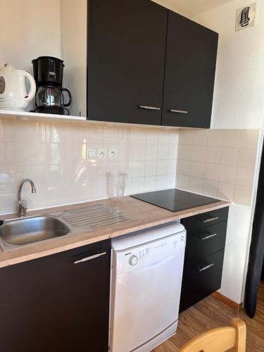 une cuisine avec un évier et un lave-vaisselle dans l'établissement Au Bachat-Bouloud, appartement 3 pièces 6 personnes avec balcon plein Sud, à Chamrousse