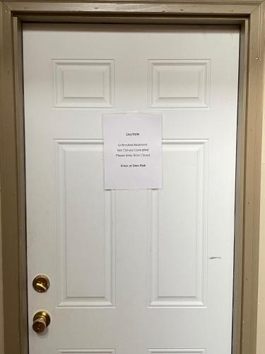 a white door with a sign on it at Three Daughters in Ferguson