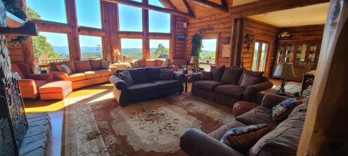 a living room with couches and chairs and windows at Trinity Lodge in Ferguson
