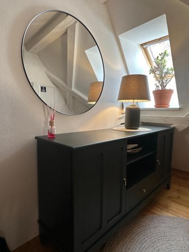 a mirror on top of a black dresser in a room at Historisches Eckermannhaus - Apartments in Weimar