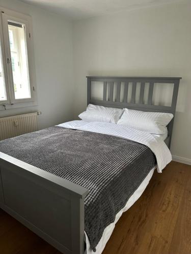a bed with a gray frame and white pillows at Historisches Eckermannhaus - Apartments in Weimar