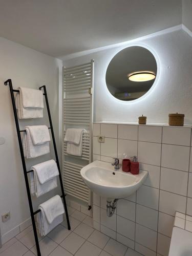a bathroom with a sink and a mirror and towels at Historisches Eckermannhaus - Apartments in Weimar