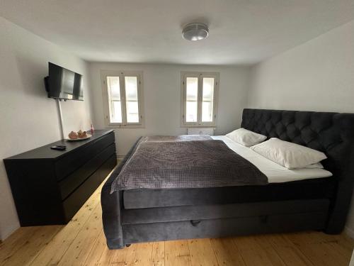 a bedroom with a large bed and a dresser at Historisches Eckermannhaus - Apartments in Weimar