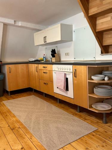 a kitchen with wooden cabinets and a stove at Historisches Eckermannhaus - Apartments in Weimar
