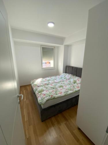 a bedroom with a bed in a room with a window at srle home in Skopje