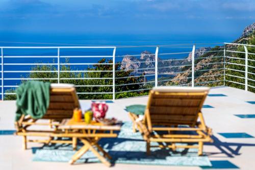 two chairs and a table on a patio with the ocean at Villa MyHeart in Massa Lubrense