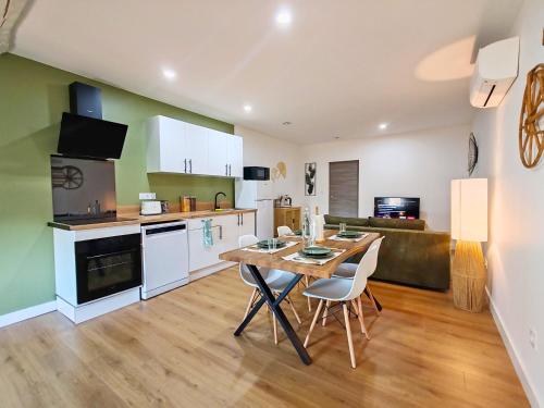 a kitchen and living room with a table and chairs at Bohème en Garonne in Tonneins