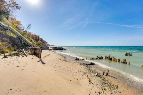 a beach with a group of wooden posts in the water at Cottage with Private Beach and Fire Pit in Manistee! in Manistee