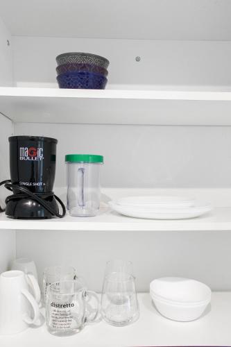 a shelf with a coffee maker and dishes on it at City View Towers - Steps to CN Tower - Pool & Hot tub - Free Parking in Toronto