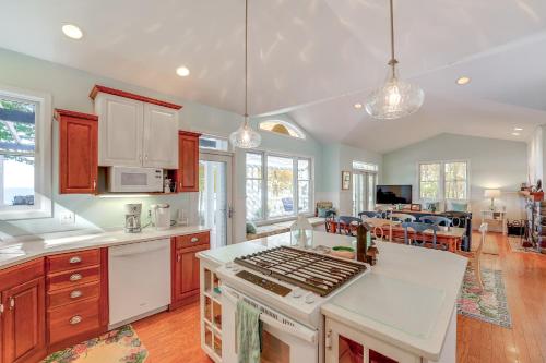 a kitchen with a stove top oven next to a living room at Cottage with Private Beach and Fire Pit in Manistee! in Manistee