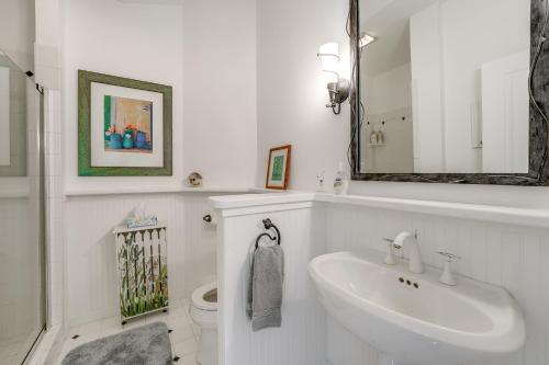 a white bathroom with a sink and a toilet at Cottage with Private Beach and Fire Pit in Manistee! in Manistee