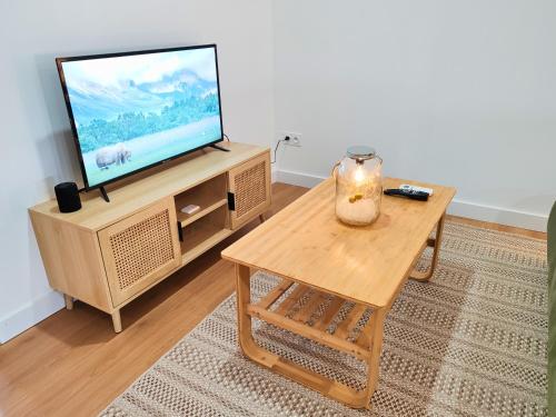 a living room with a tv and a coffee table at Bohème en Garonne in Tonneins