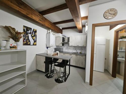 a kitchen with a table and a clock on the wall at Monnalisa House - Imola Centro Storico - Appartamento Indipendente in Imola