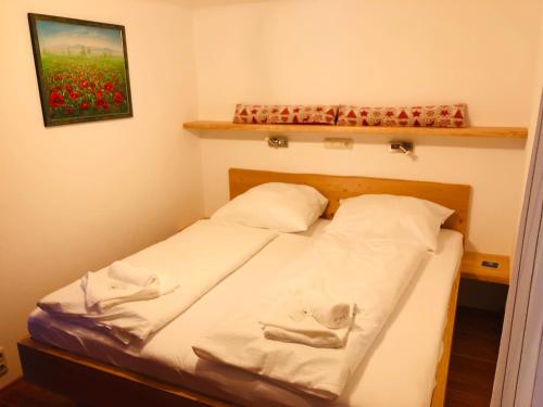 a bedroom with a bed with white sheets and red flowers at Ski in & Ski out Apartment at Chalet Heinrich in Sonnenalpe Nassfeld