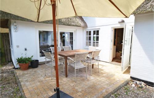 an umbrella on a patio with a table and chairs at Two-Bedroom Holiday Home In Grasten in Gråsten
