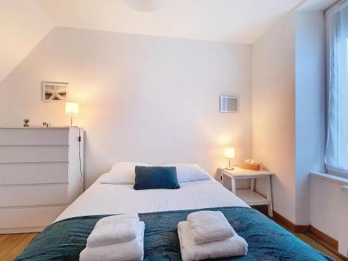 a bedroom with a bed with towels on it at Charmant appartement sur 3 niveaux in Beaumont-Hague