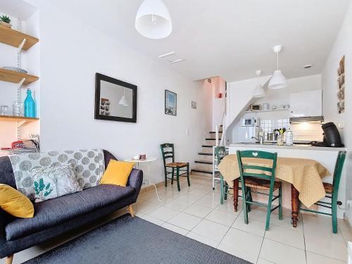 a living room with a couch and a table at Charmant appartement sur 3 niveaux in Beaumont-Hague