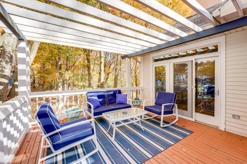 a porch with blue chairs and a glass table at Cottage with Private Beach and Fire Pit in Manistee! in Manistee
