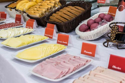 a table filled with different types of cheese and bread at Tri Hotel Bento Gonçalves in Bento Gonçalves