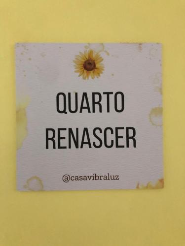 a sign with a sunflower on it on a wall at Casa Vibra Luz Guest House Familiar in Florianópolis