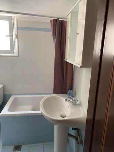 a bathroom with a sink and a bath tub at Sweet Suite in Serres