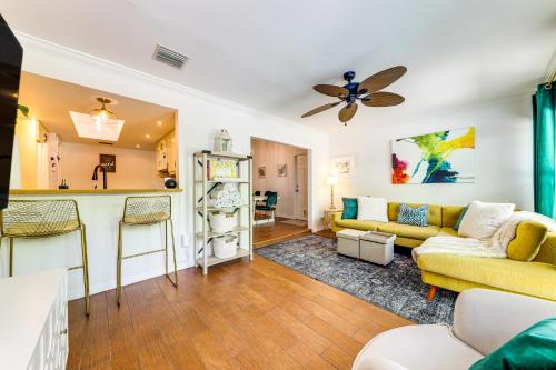 a living room with a yellow couch and a kitchen at Tropical Pool Oasis on quarter Acre by Downtown Stuart in Stuart