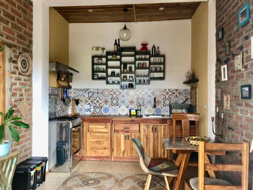 a kitchen with a table and a brick wall at Nativo Lodge Cabaña in Playas