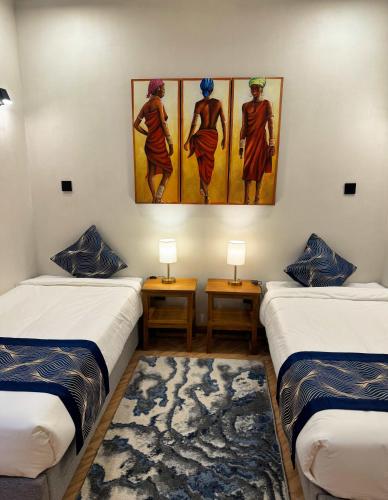 a room with three beds and a painting on the wall at Moshono Hillside in Arusha