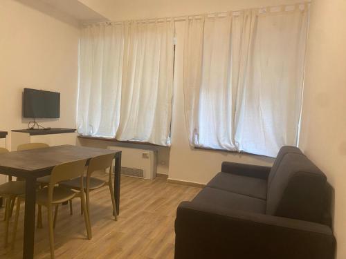 un soggiorno con un tavolo e un divano di Appartamenti 5min da stazione centrale a Milano