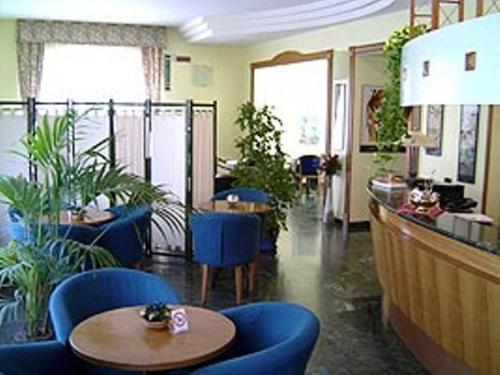 a restaurant with blue chairs and a table in a room at Hotel Alexander in Fiorano Modenese