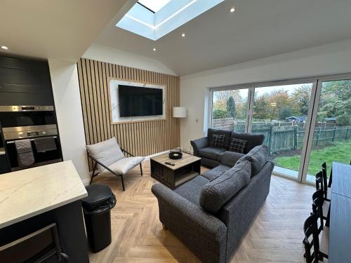 a living room with a couch and a tv at 6 bedroom house in Orpington in Farnborough