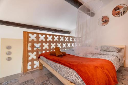 une chambre avec un lit avec une couverture orange dans l'établissement immeuble entier pour groupe, à Marseille