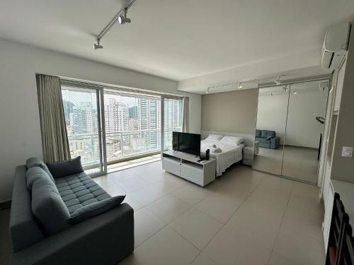 un soggiorno con un divano e un letto di Vista Mar Unlimited Frente Mar Ar Condicionado Garagem Arrumação Andar Alto e piscina aquecida, sauna e muito mais! a Santos